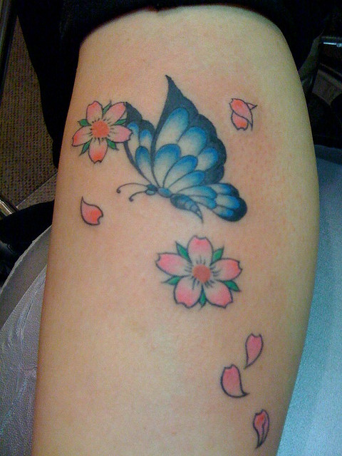 Beautiful blue butterfly tattoo with flowers